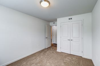 A white door is in a room with carpeting.